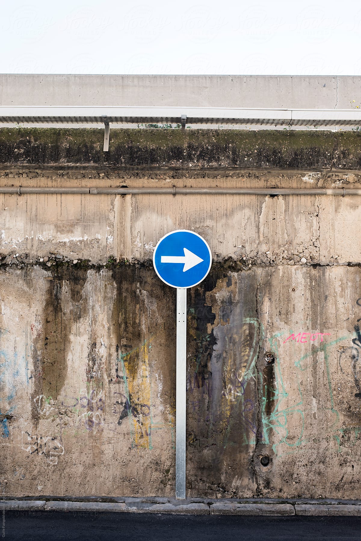 Road sign showing direction against grunge wall