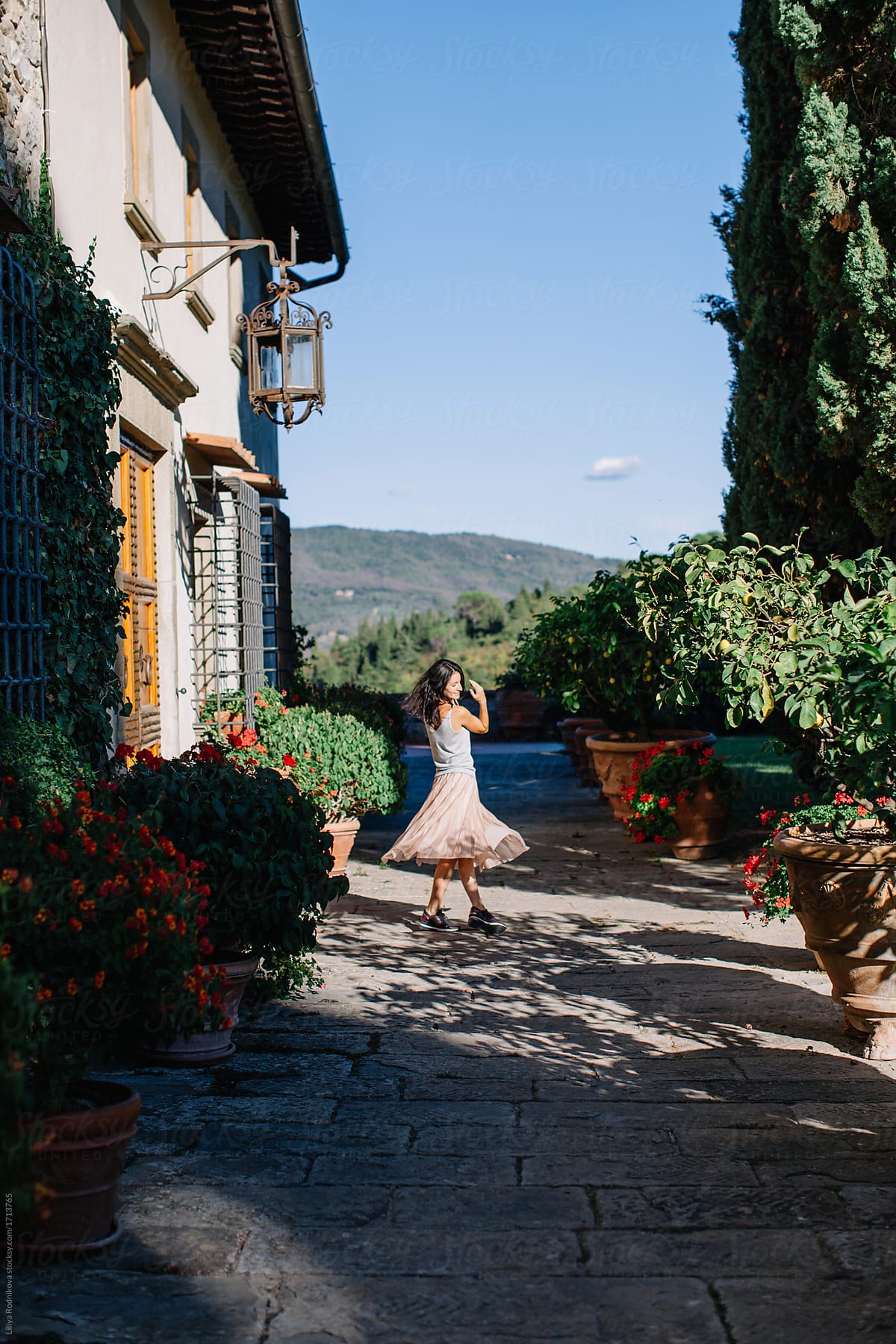 Young happy woman swirling in lovely place in Italy