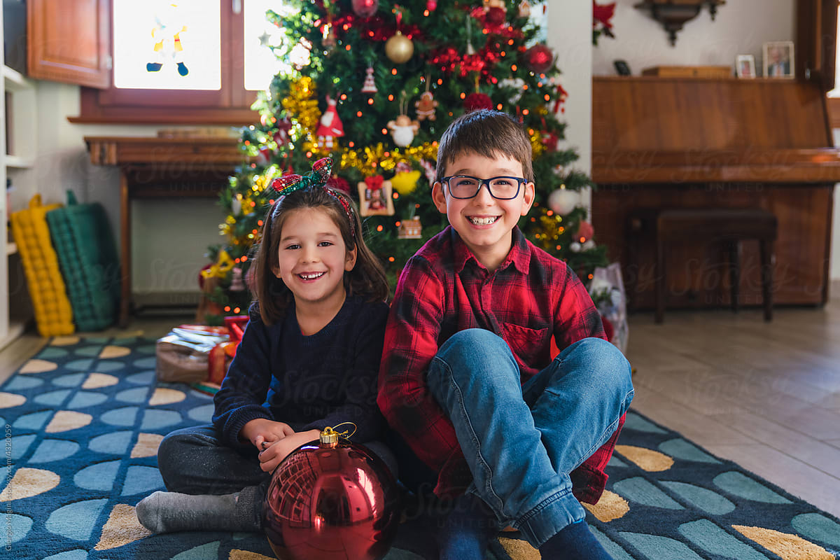 Siblings Portrait in front of a Christmas Tree