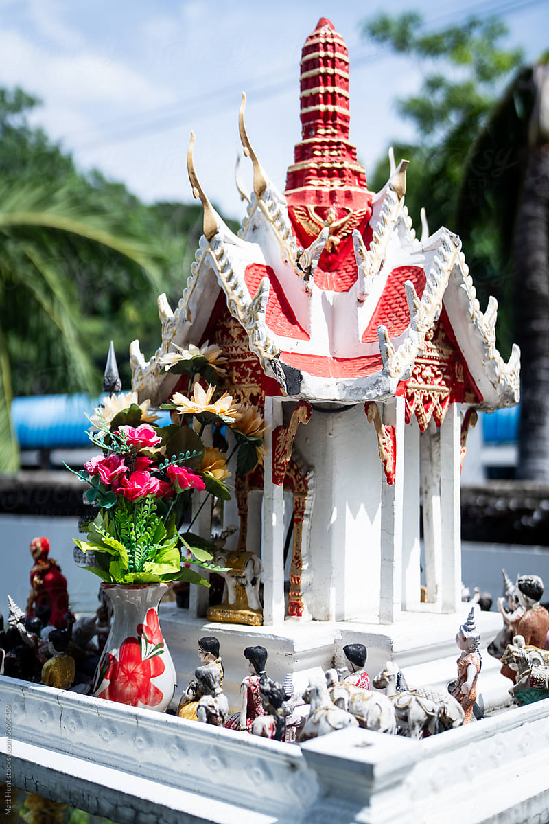 Thai spirit house with tiny figurines on the street in Bangkok