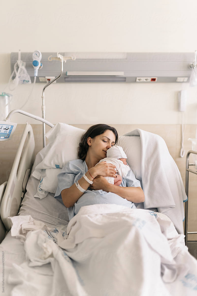 Mother sleeping with her baby in the hospital