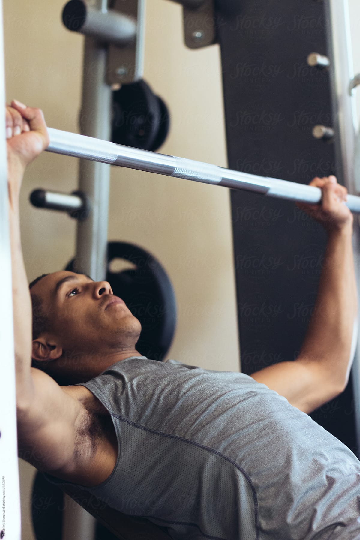 Young Man Exercising in Gym with Bench Press