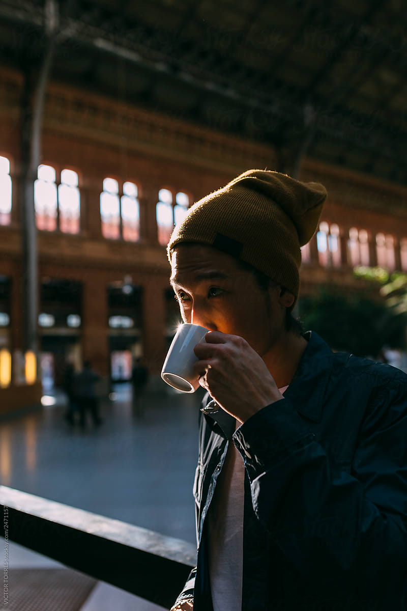 Asian young tourist drinking coffee in the train station