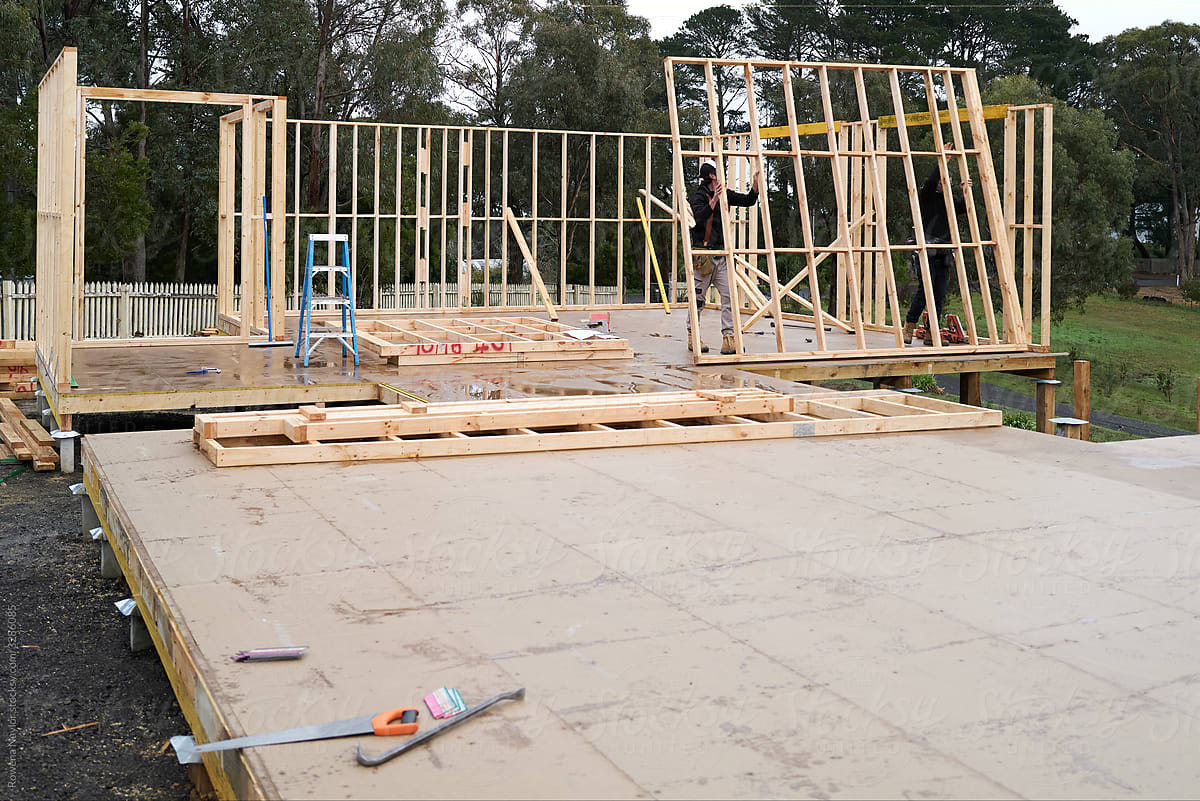 Builders constructing house timber frames