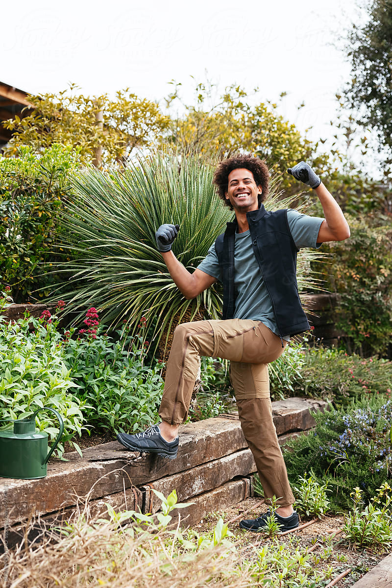 Happy gardener showing muscles during work