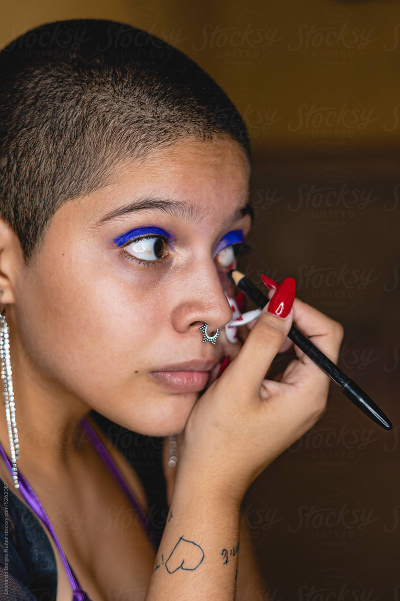 Close-up of a bisexual woman outlining her eyes