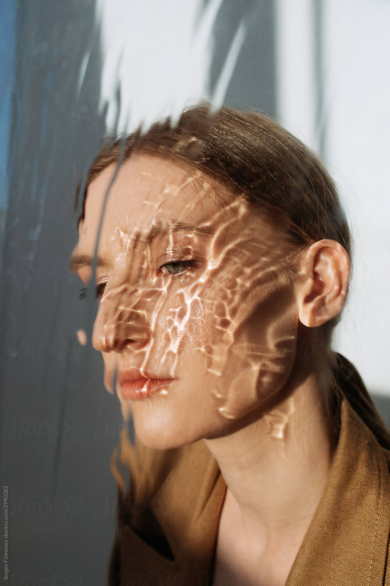 Stylish model behind wet glass