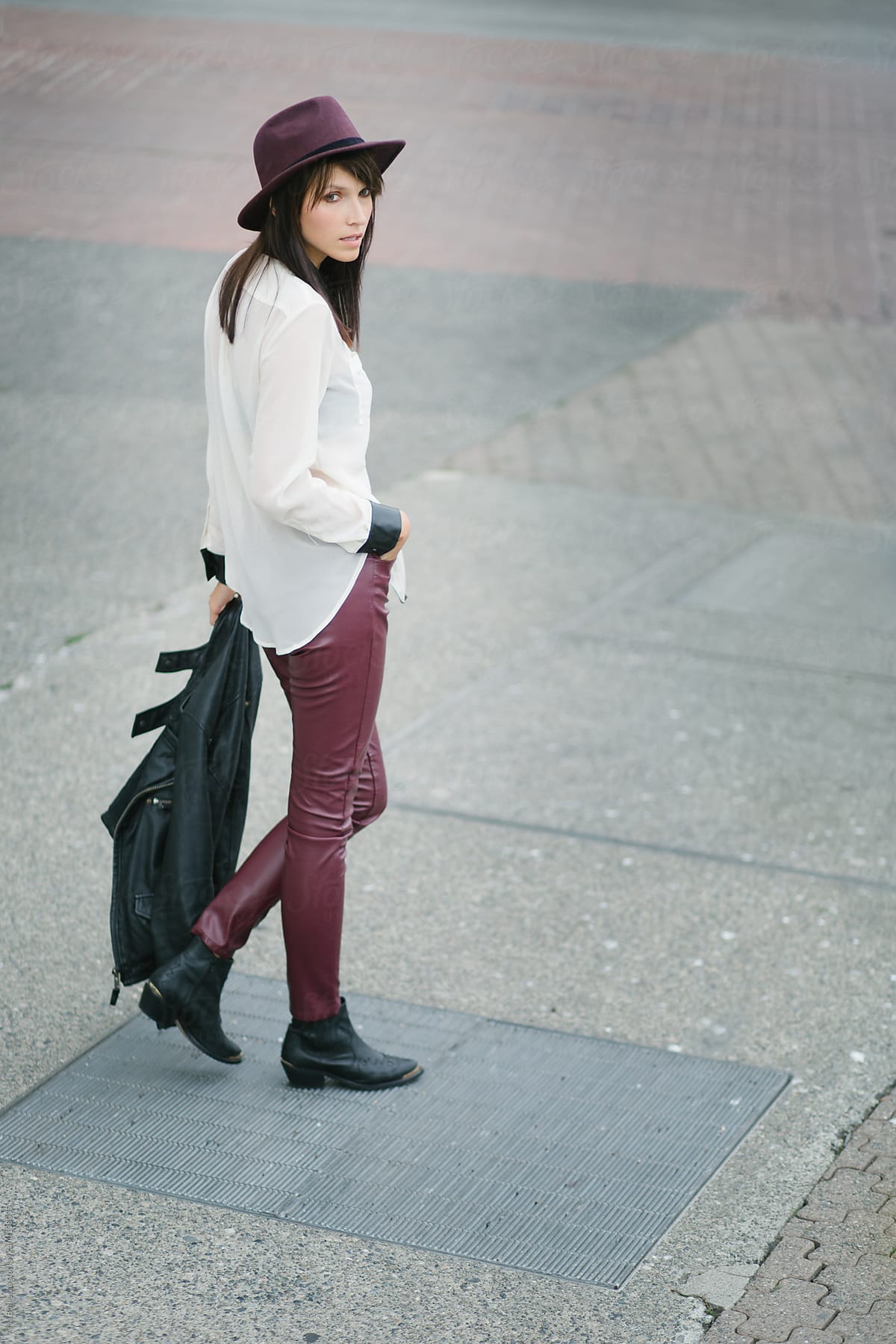 A stylish brunette standing on the street looking  back