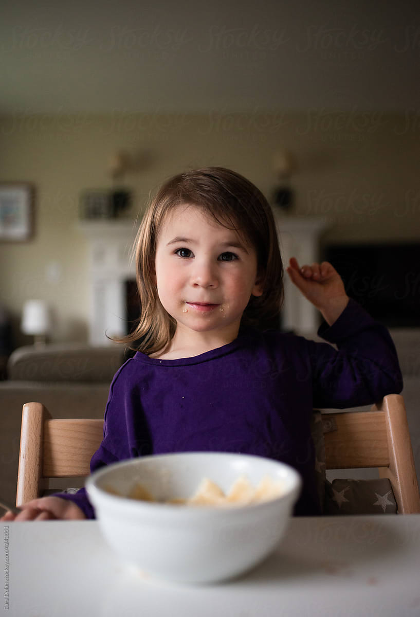 Child Sitting at Table Eating a Bowl of Pasta