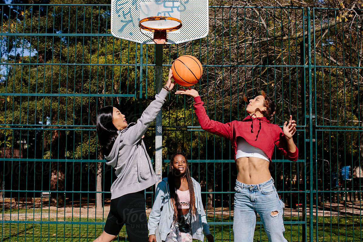 Three girls playing basketball