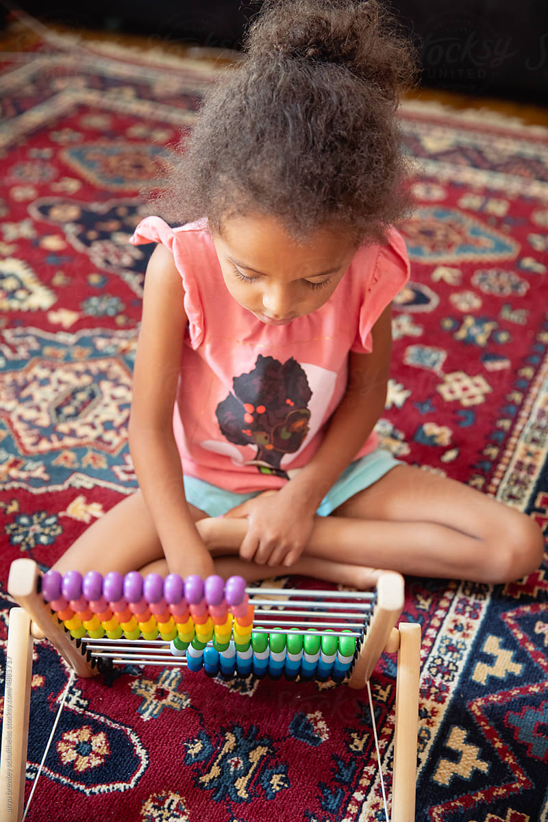 A child playing with a rainbow coloured abacus