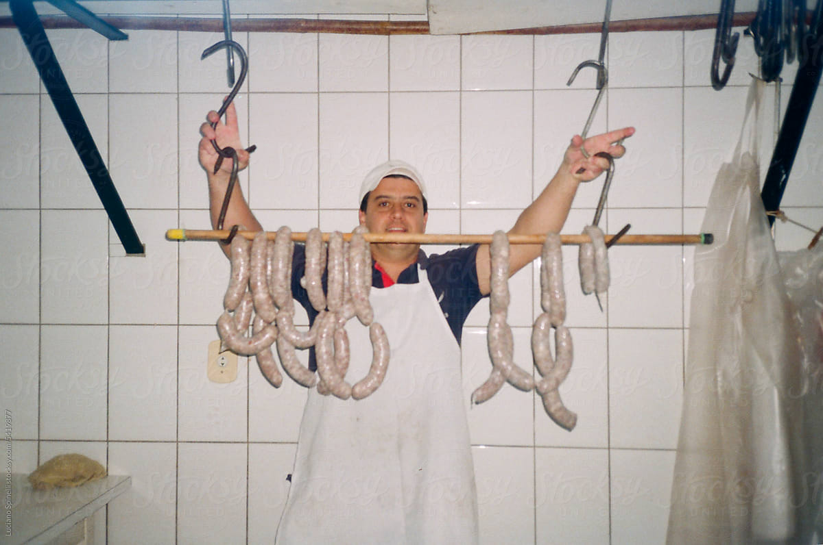 Butcher hanging handmade sausages during artisanal process