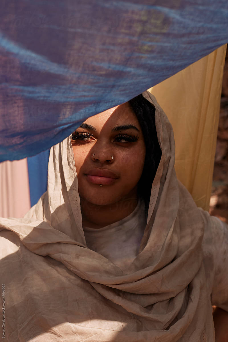 Portrait of a Gen Z Woman Traveler Draped in Moroccan Fabrics