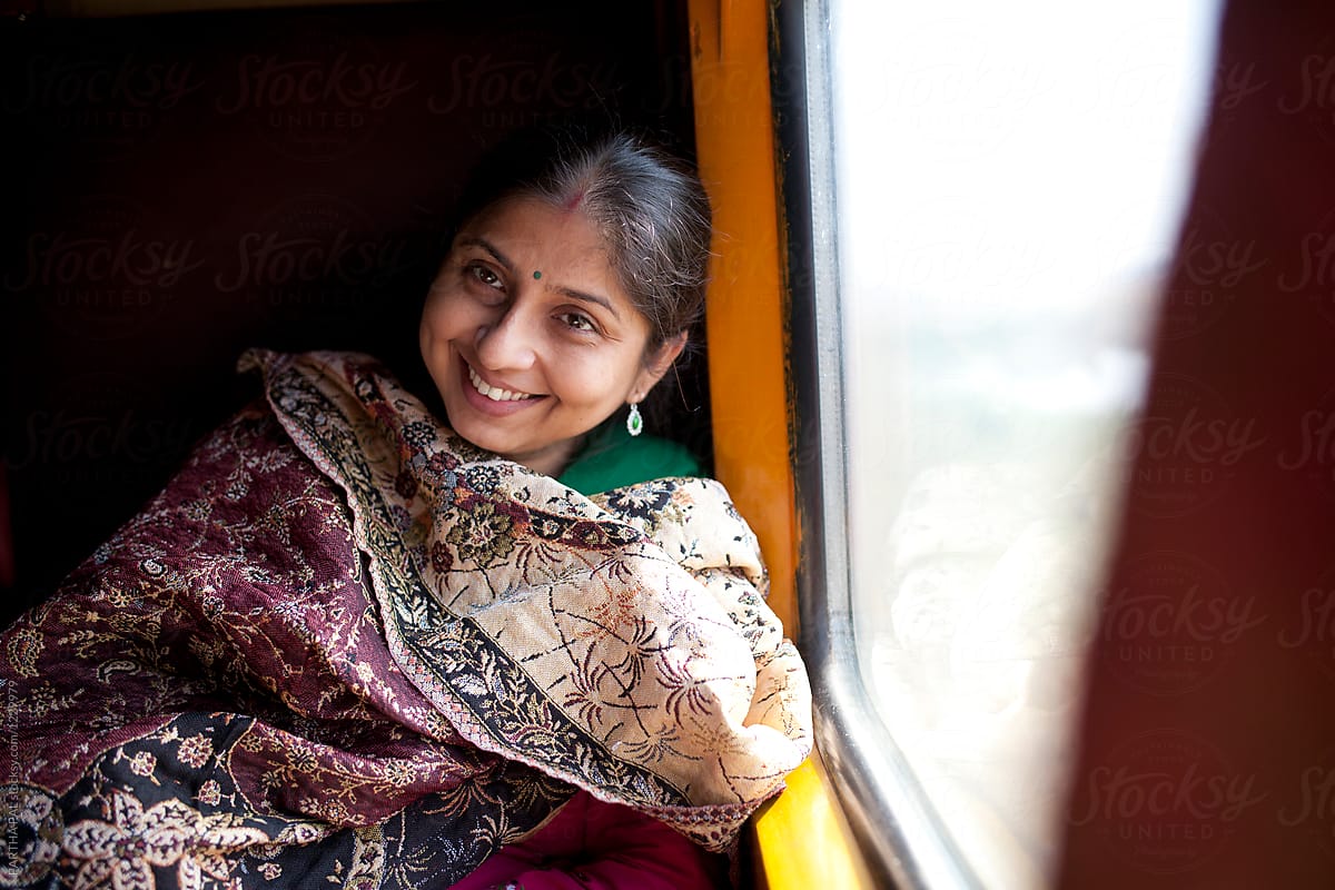 Indian woman relaxing and laughing inside train