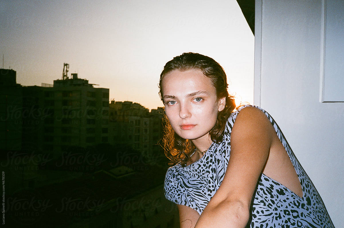 Portrait of a woman in the balcony during hot summer sunset with flash