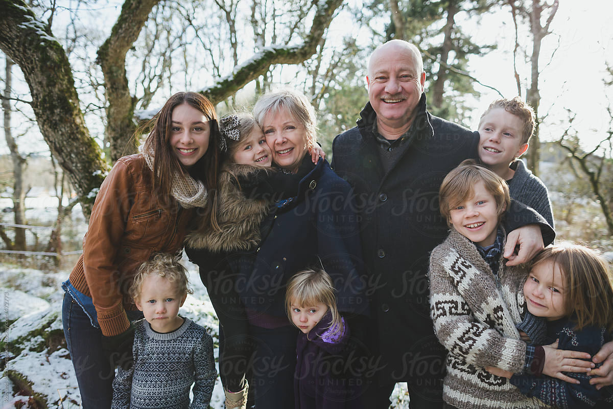 Happy grandparents enjoying their grand children outside in winter - family portrait