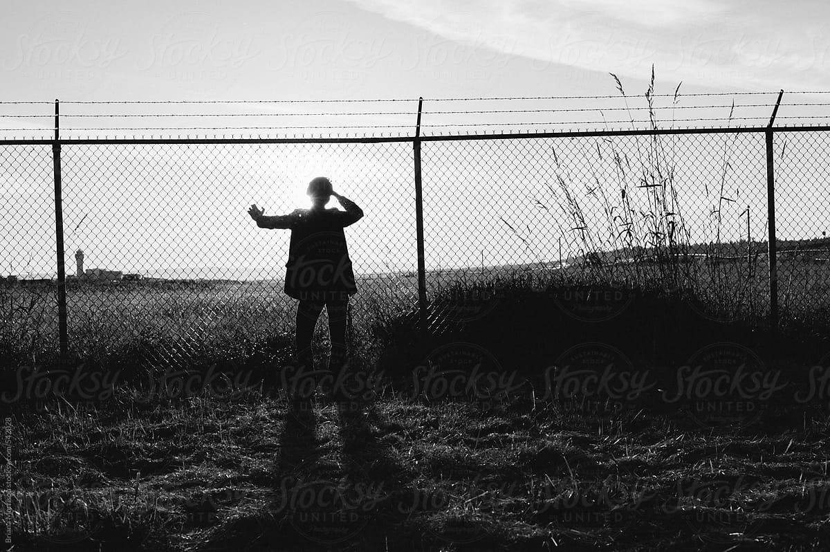 Silhouette Of A Man Behind A Barbed Wire Fence Del Colaborador De silhouette-of-a-man-behind-a-barbed-wire-fence-del-colaborador-de