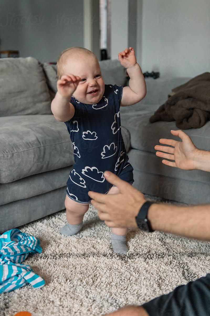 Dad encouraging baby to take first steps