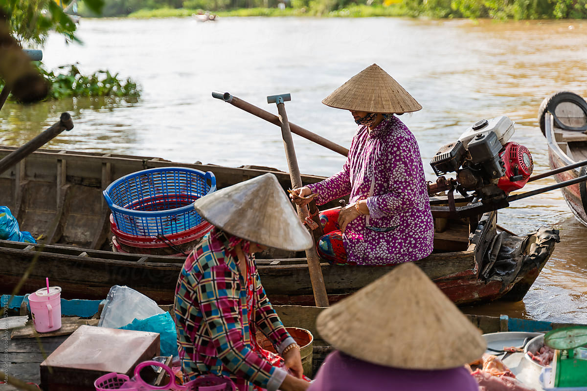 Women on a boat at the floating market in Vietnam