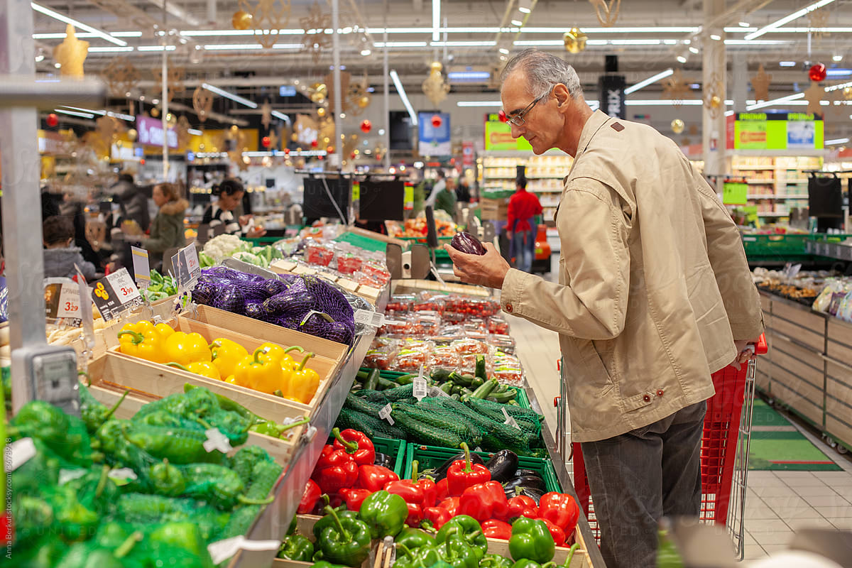 senior elderly person in grocery store, food shopping in supermarket