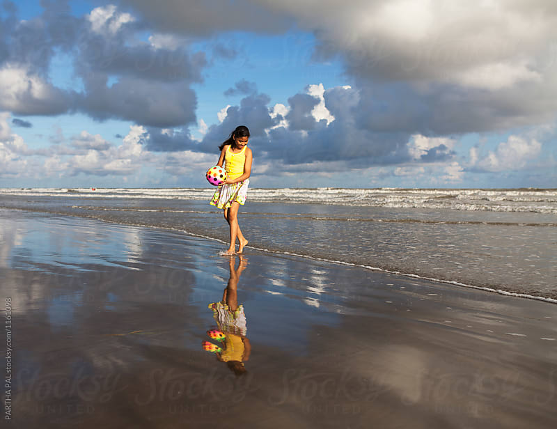 A teenage girl enjoying holiday in a sea beach and holding  a colorful ball