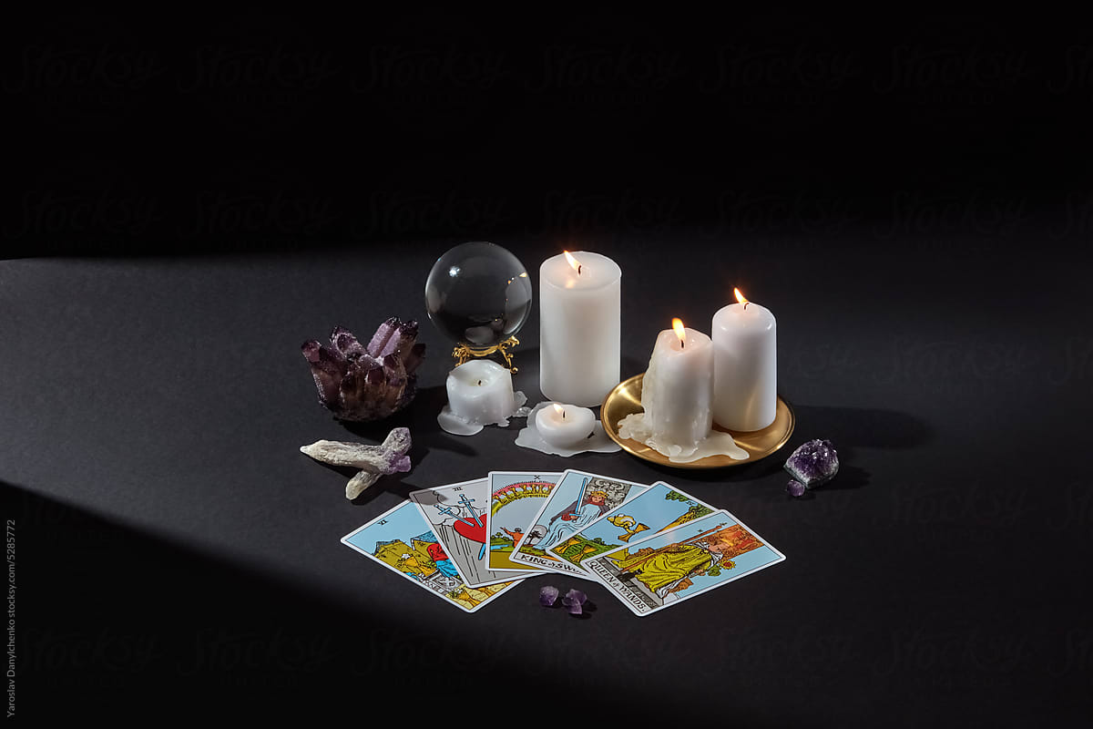 Tarot cards spread with crystal sphere, candles and quartz.