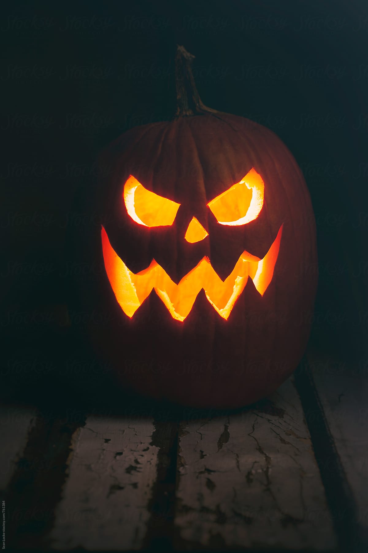 Halloween: Evil Pumpkin Sits On Rustic Wooden Table