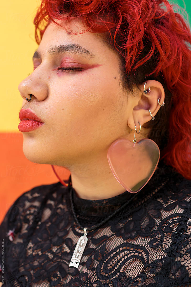 Red hair person with pierced ears in profile with eyes closed
