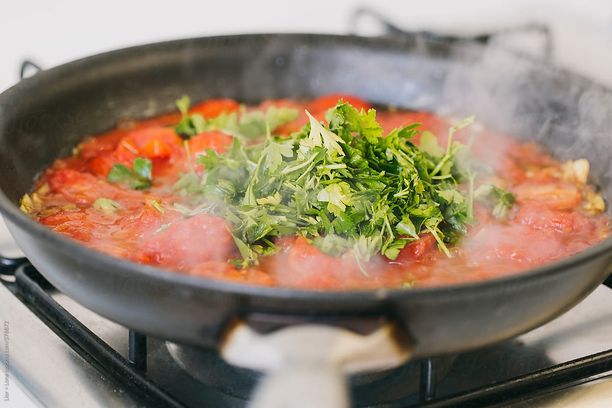 Tomato sauce with fresh parsley cooking in a pan