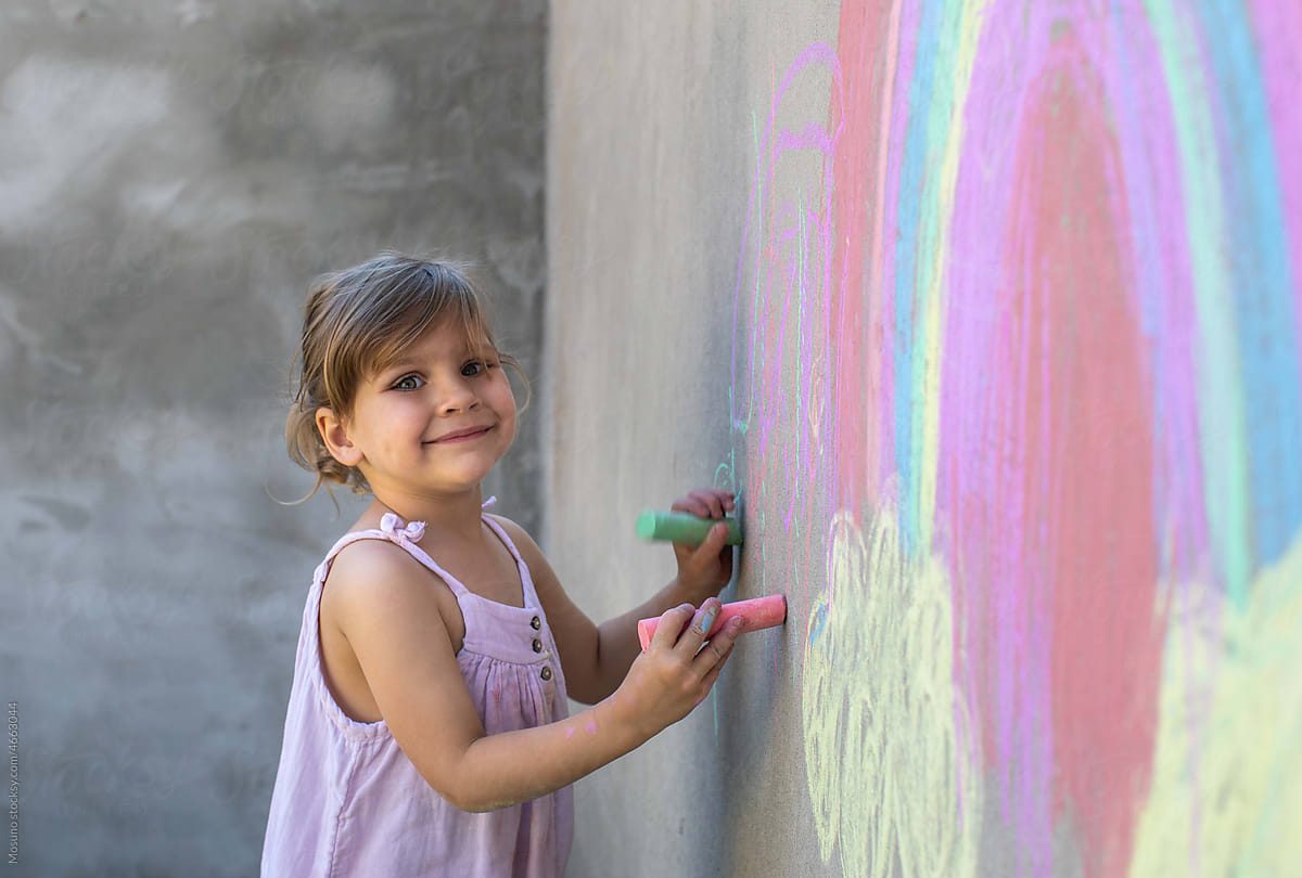 Cute girl drawing on the wall