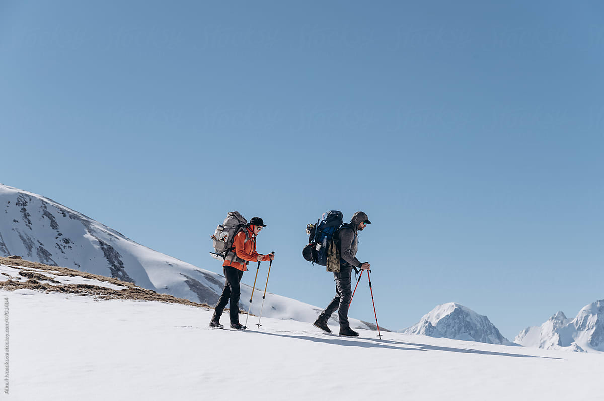 Hikers walking on snowy terrain in nature