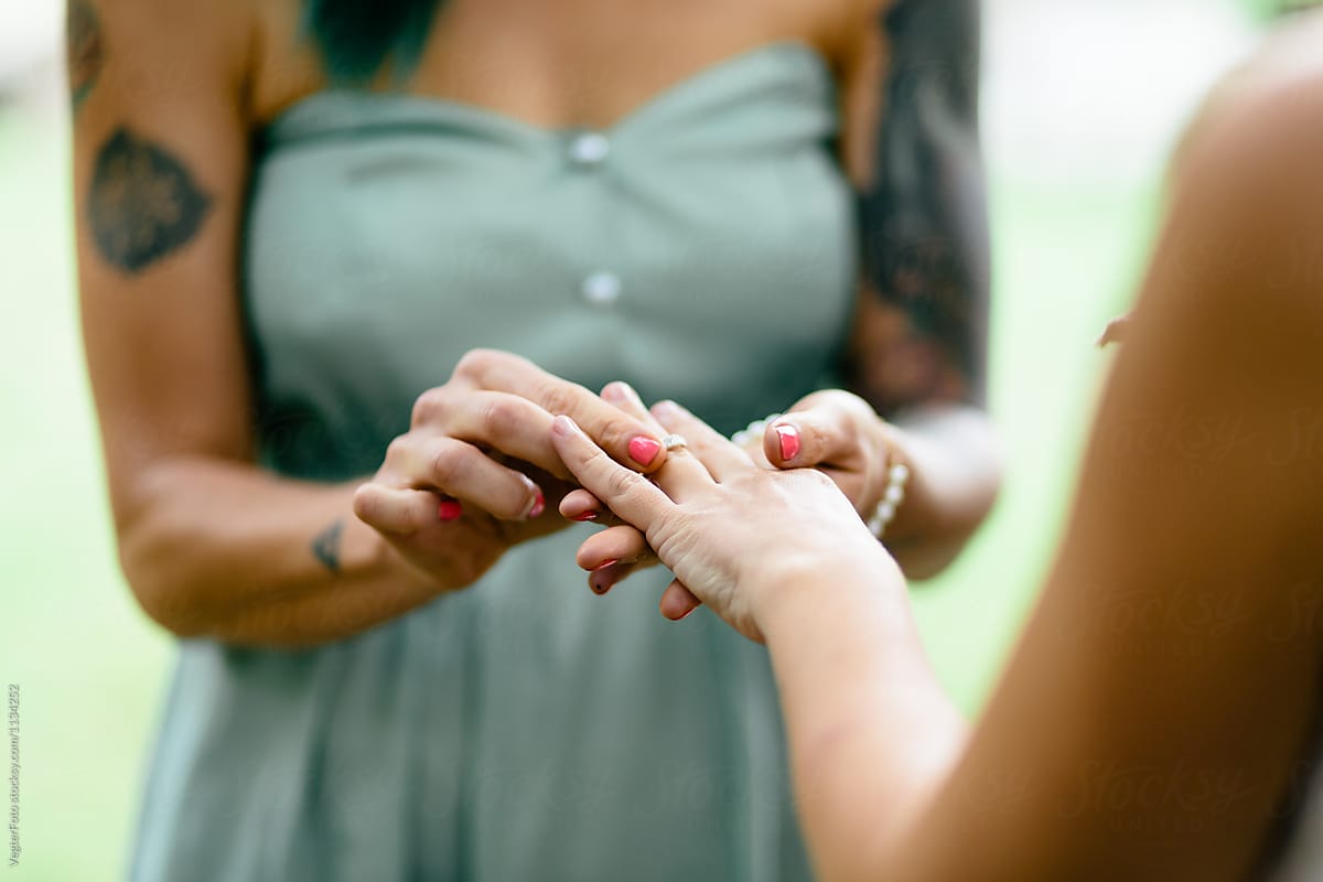 lesbian couple exchanging rings