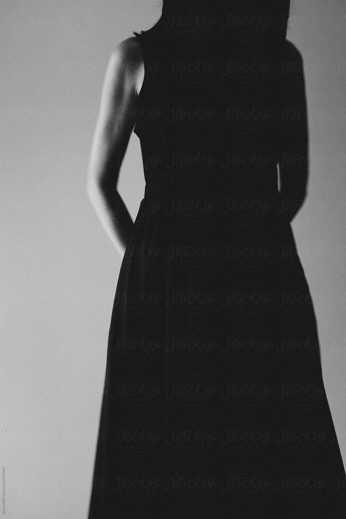 Moody, black and white image of mysterious woman wearing a long black dress