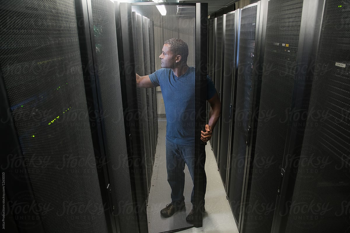 Technician looks inside a server room cabinet