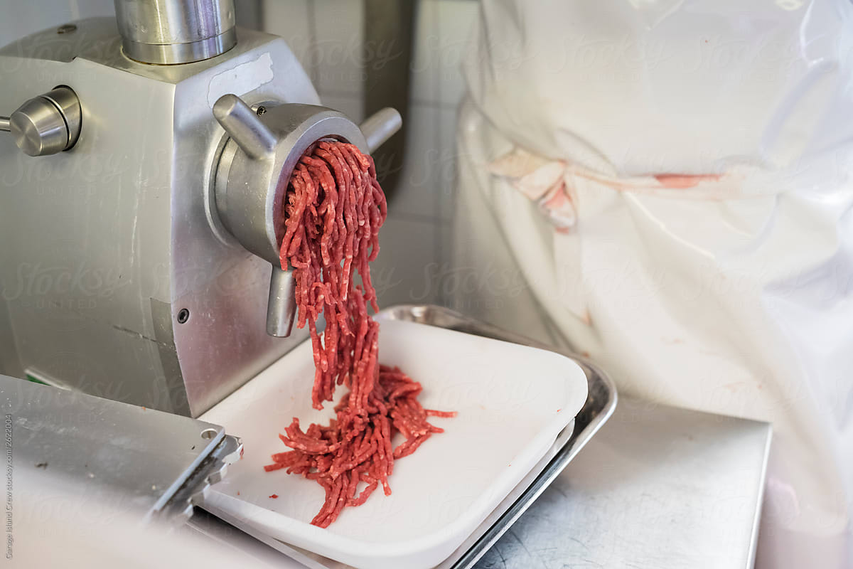Butcher using a minced meat machine