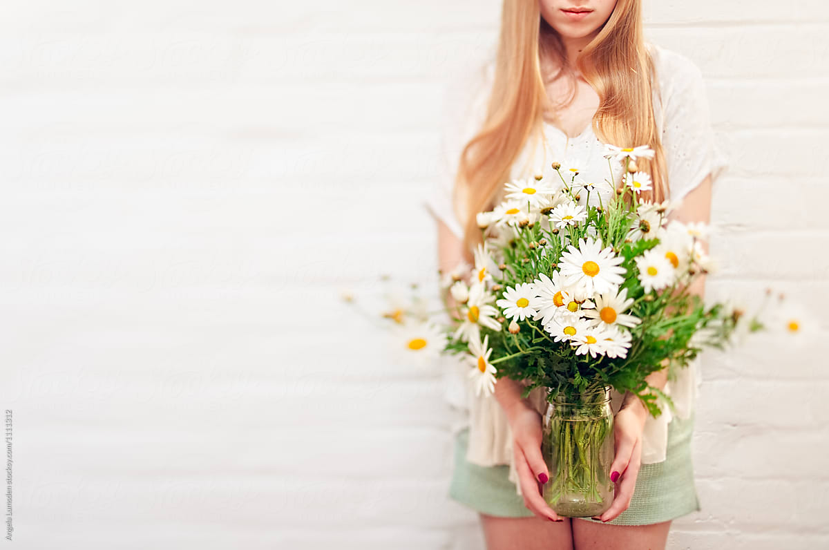 Girl holding a bunch of daisies in spring