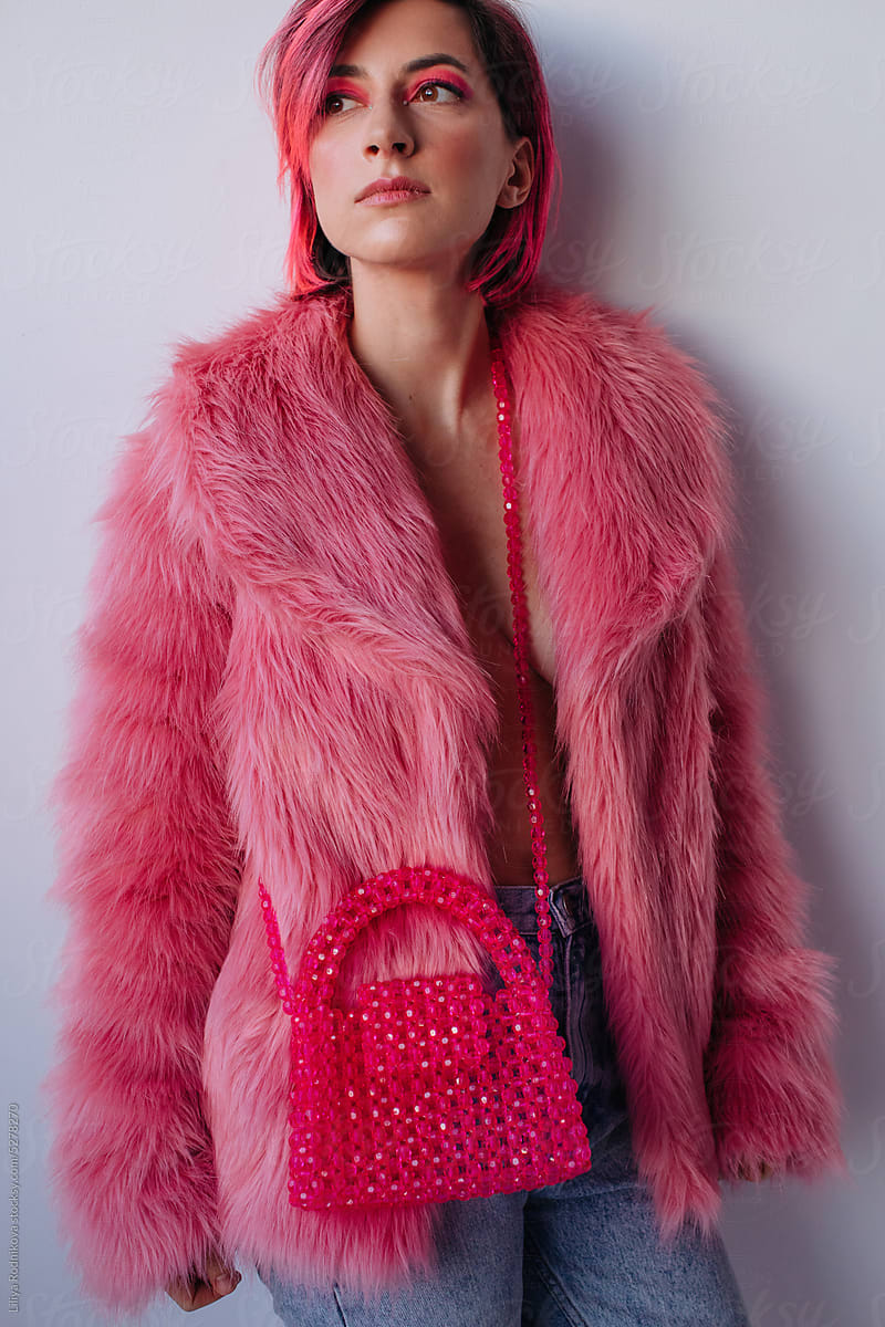 Trendy woman in pink fake fur coat with extravagant make up