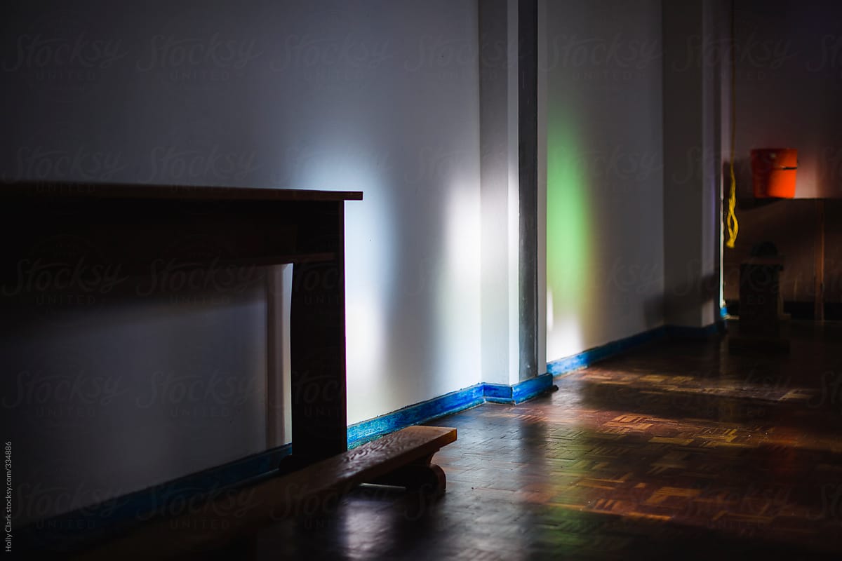 Colorful light filtered through stained-glass on white walls.