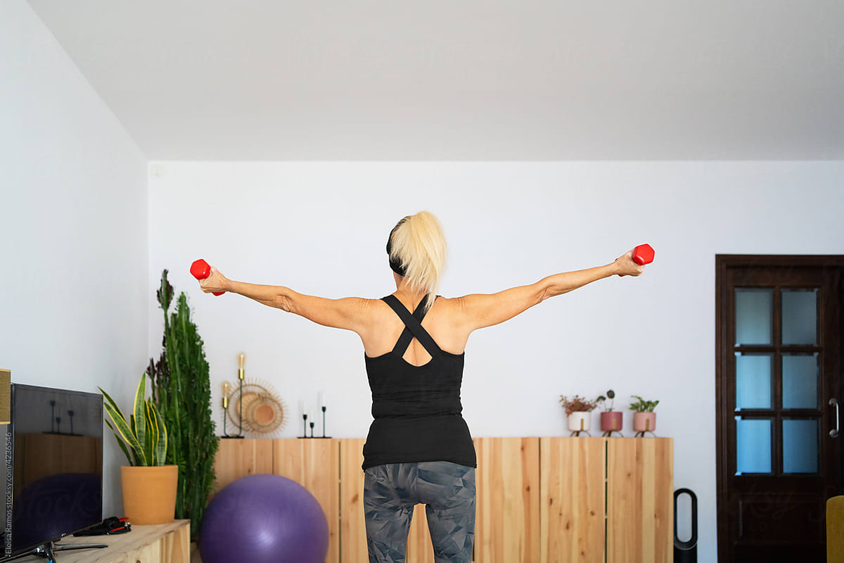 Senior woman exercising arms with dumbbells