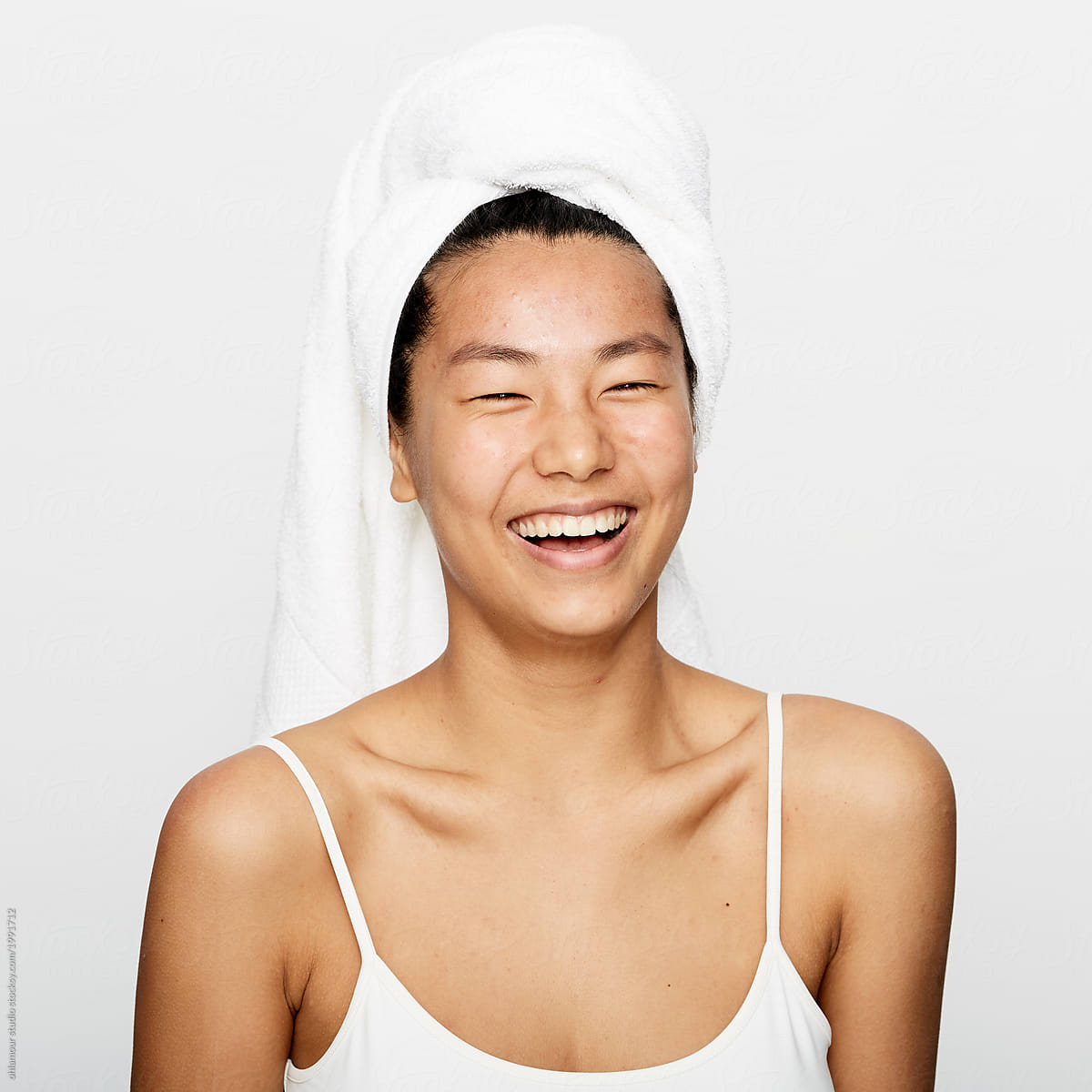 Young beautiful asian woman smiling after refreshing facial treatment.