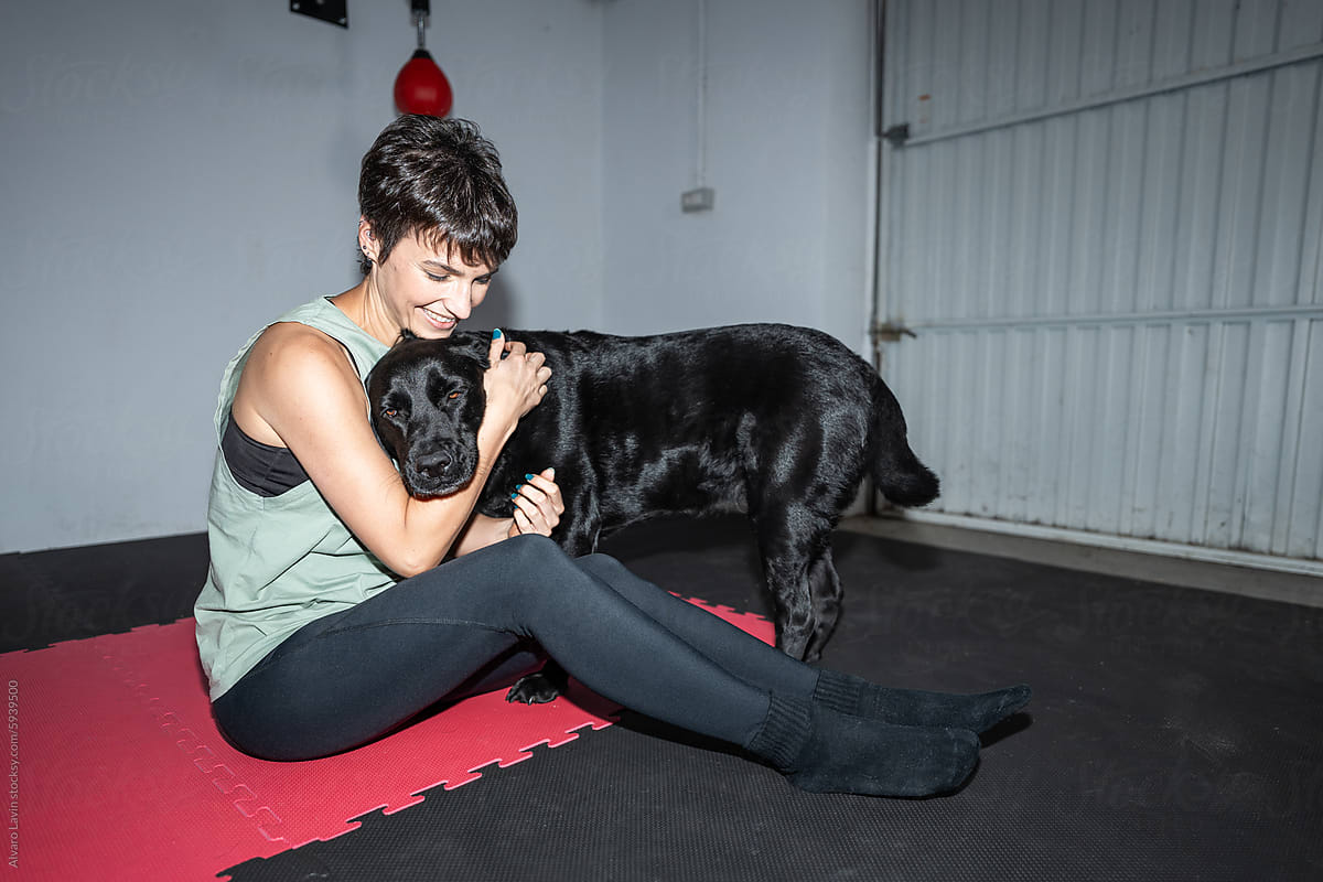 Woman Petting Dog During Home Gym Workout