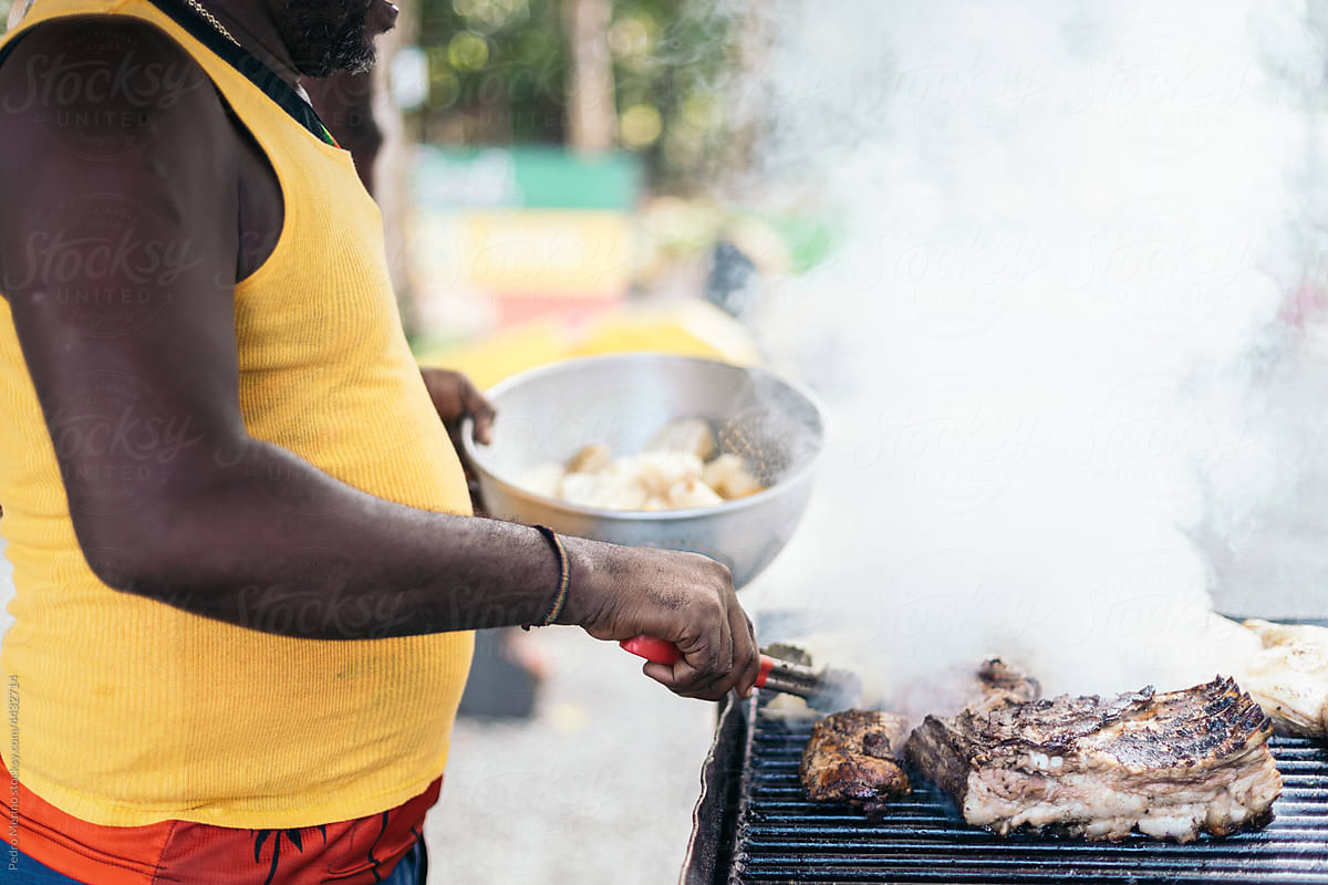 Faceless black person cooking on a barbeque