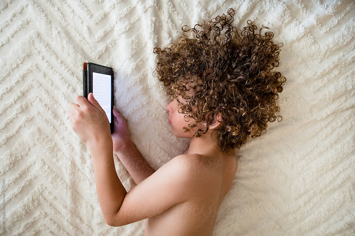 Boy reading on tablet with hair spread out