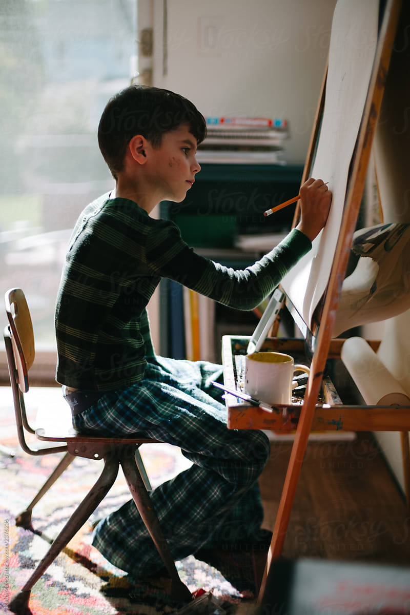 boy paints at easel