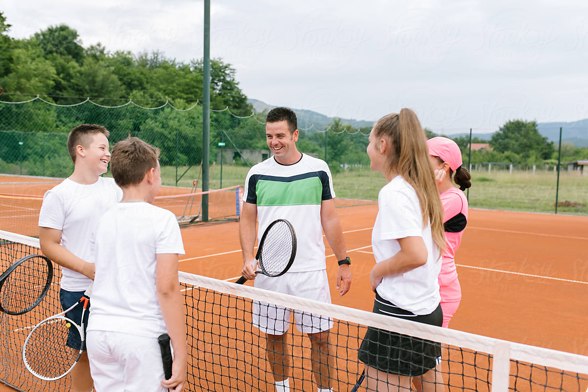A Tennis Coach With His Young Students