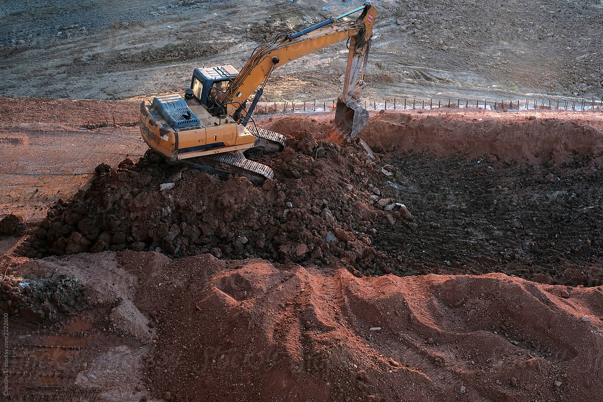 Excavator at work, on a layered mound
