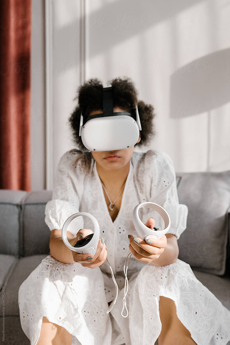 Black woman playing VR videogame at home