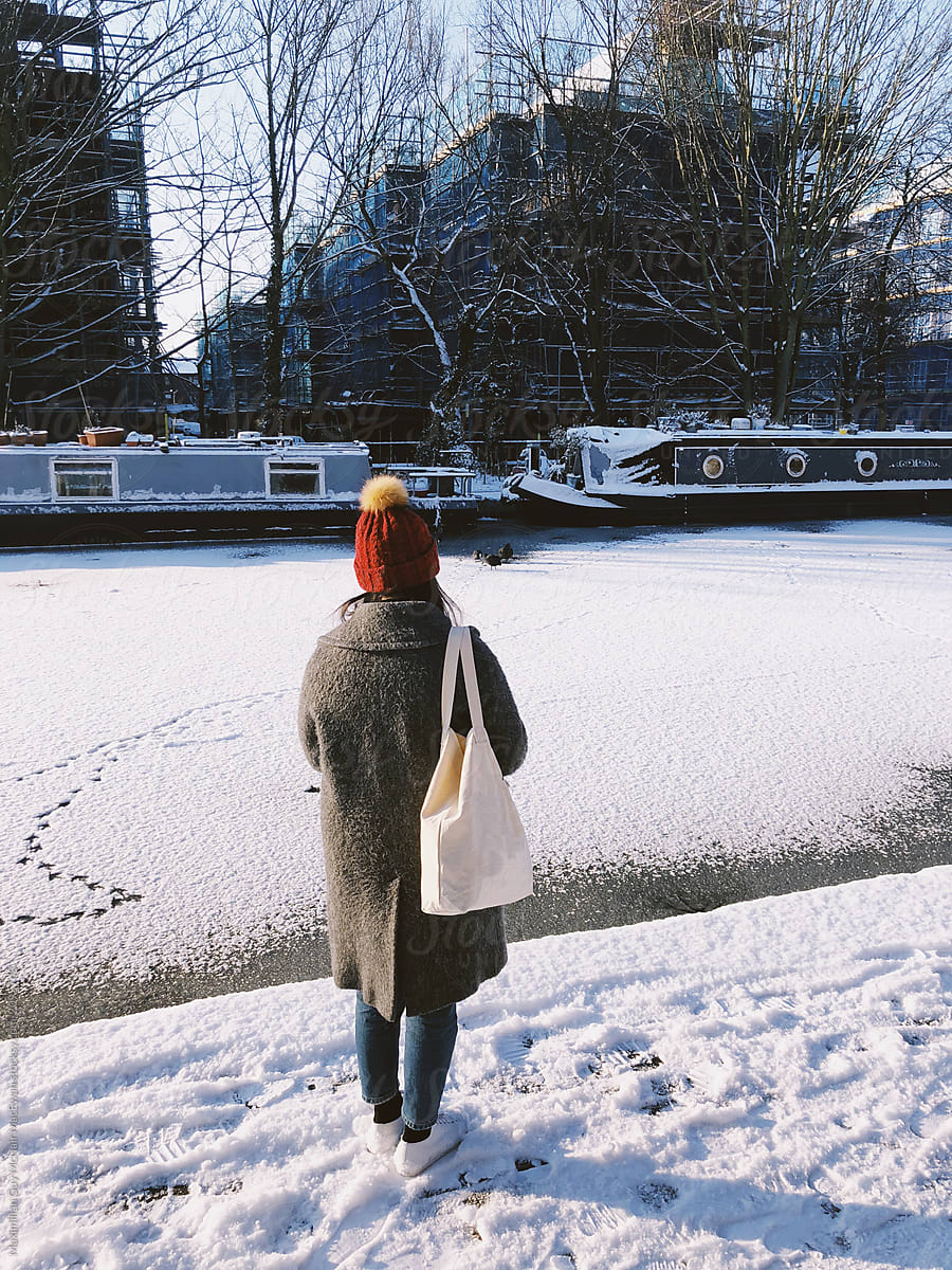 A girl walking alone in the park on a snowy morning