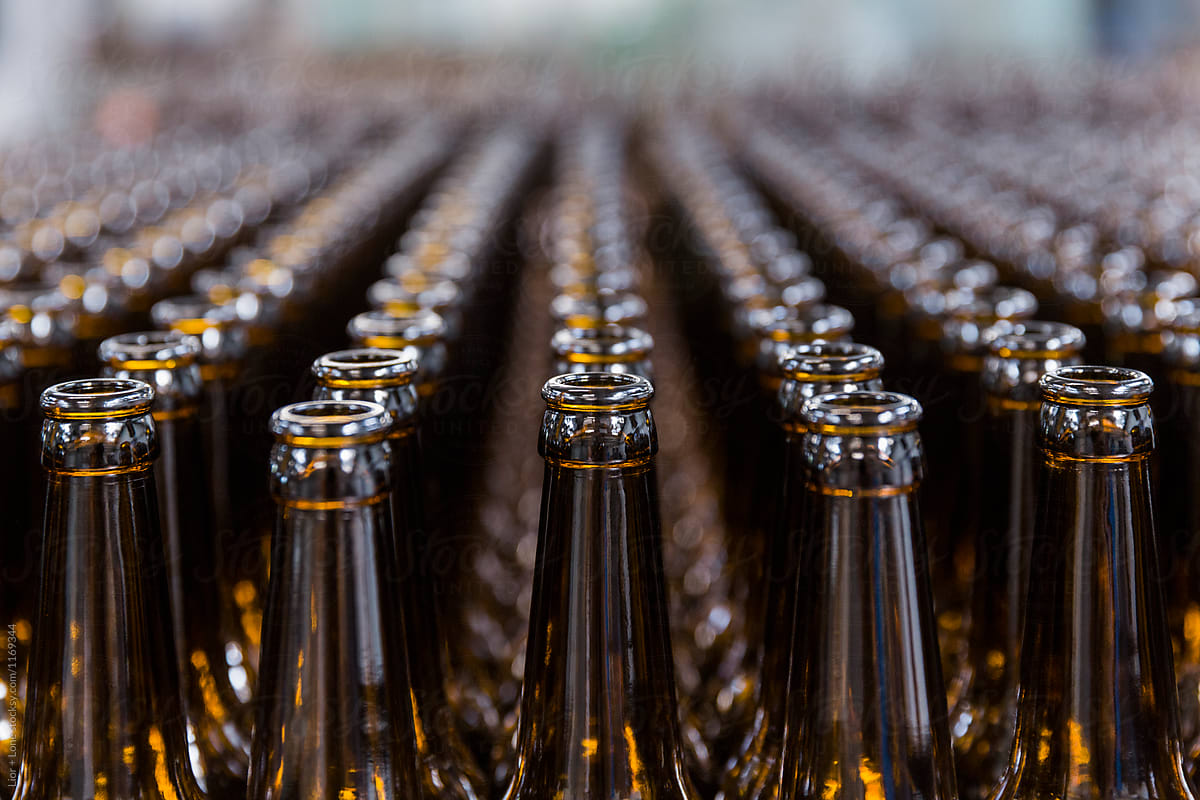 Symmetrical rows of empty beer bottles in shallow focus