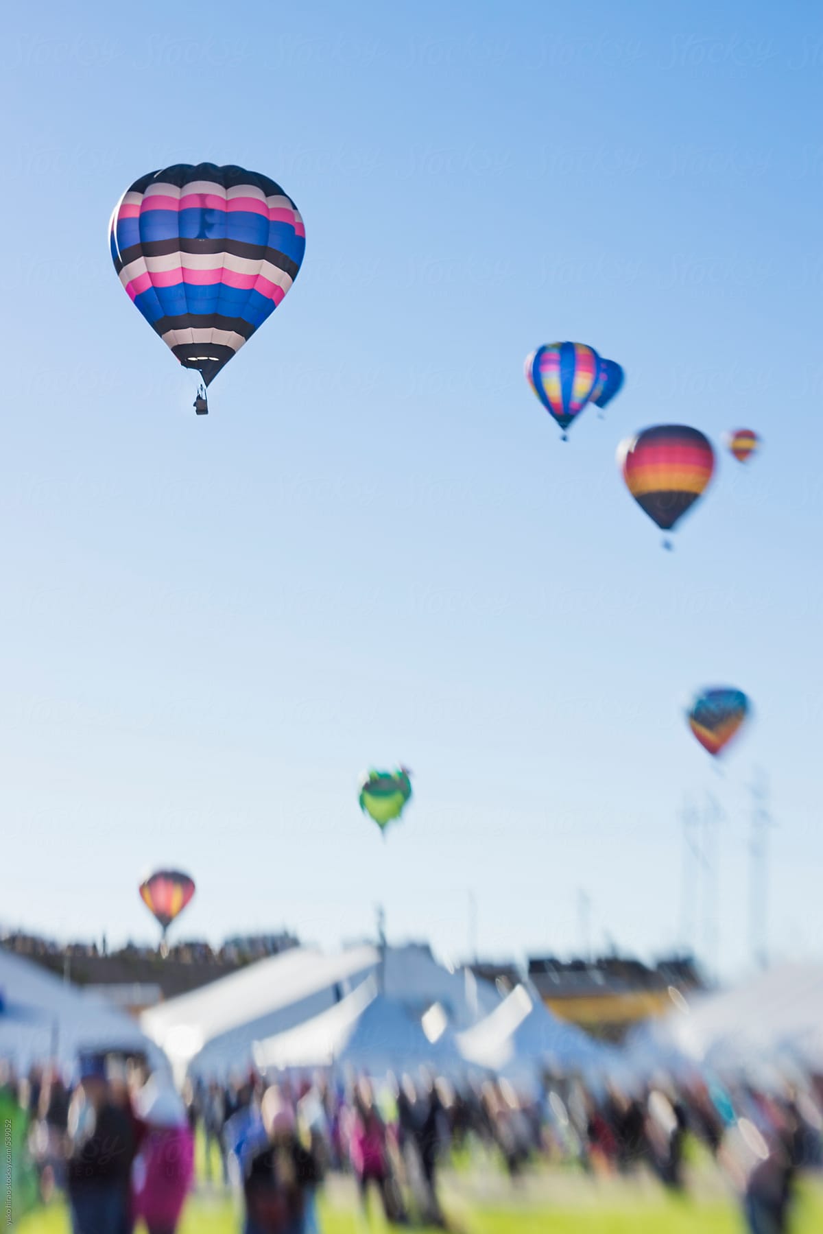 Hot air balloons flying over people at a festival